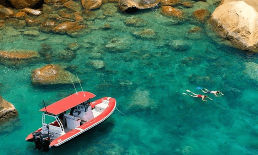 Aerial view of a boat and snorkelers in the waters of the great barrier reef.